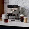Ninja ES601EU Luxe Premium Siebträger-Espressomaschine 2 Maschinen in 1 – für milden oder starken Espresso und Filterkaffee. Barista Assist Technology kalibriert automatisch. Automatisches Aufschäumen mit Milch oder Milchalternative. Integriertes Kegelmahlwerk mit 25 Stufen und Waage. Brühtemperatur 90-96 °C und der Tassenwärmer hält dein Kaffee heiß.